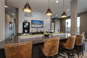 a large kitchen with a bar and chairs and a television  at Watermark on Twenty Mile, Parker